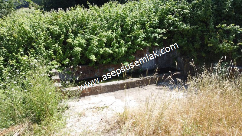 10.008 m2 Yatırımlık Tarla Bağ-Bahçe Su Çeşme Var. Yolu Yok.